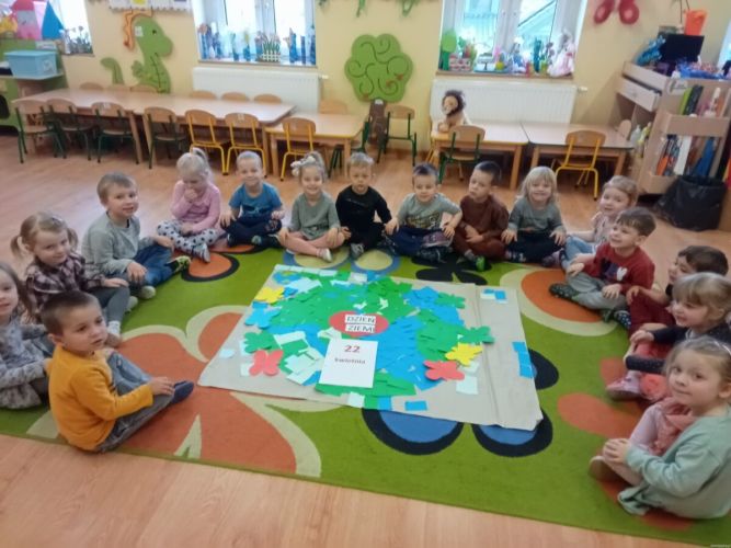 Dzieci siedzą na dywanie.