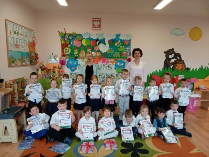 Dzieci stoją i trzymają dyplom.