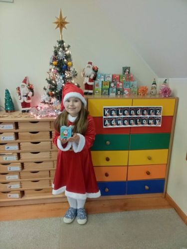 Dziewczynka trzyma niespodziankę z kalendarza adwentowego