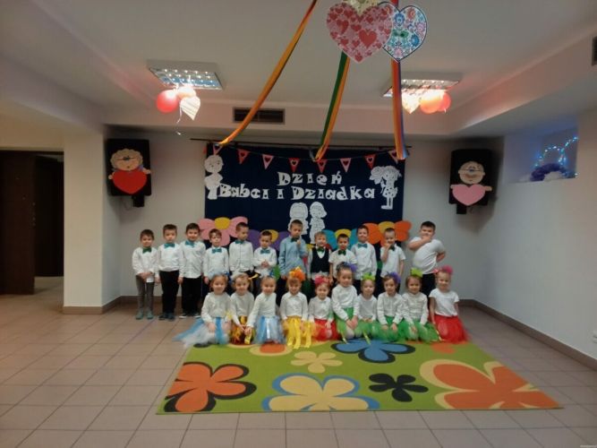 Dzieci stoją przy tablicy dekoracyjnej.